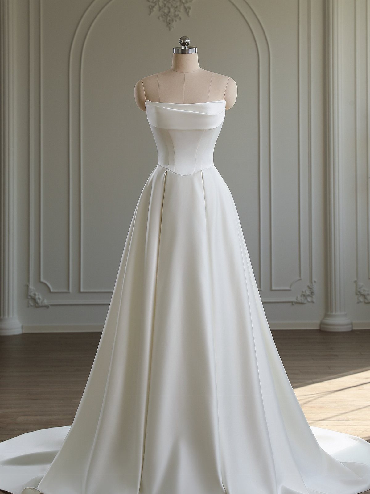 White satin wedding dress with a strapless neckline and A-line silhouette on a mannequin.
