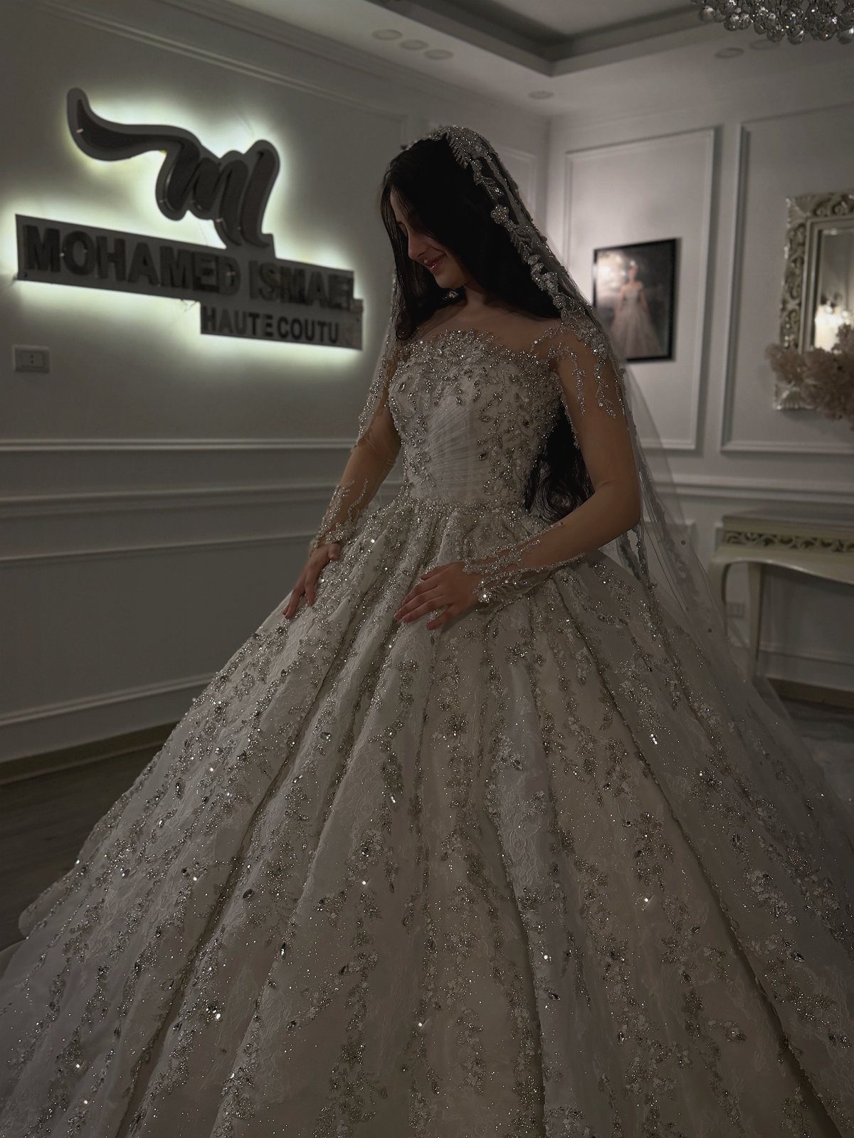 Woman in a sparkling white wedding gown with intricate beading and a full skirt.
