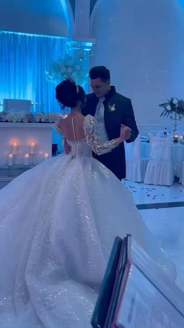 Bride in a sparkling white princess style wedding dress dancing with her groom.