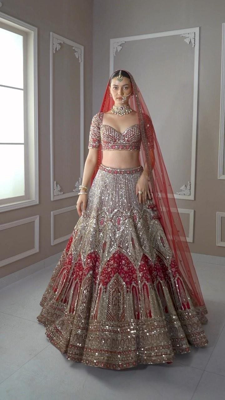 10 Red Wedding Dresses for Brides Who Want Color 5 Woman in a red and silver embroidered lehenga with a sheer red veil.