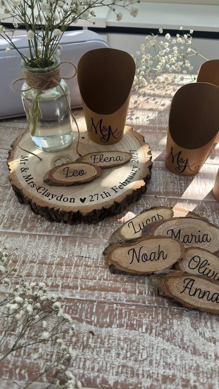 Engraved wooden name tags for place settings on a rustic white wooden table