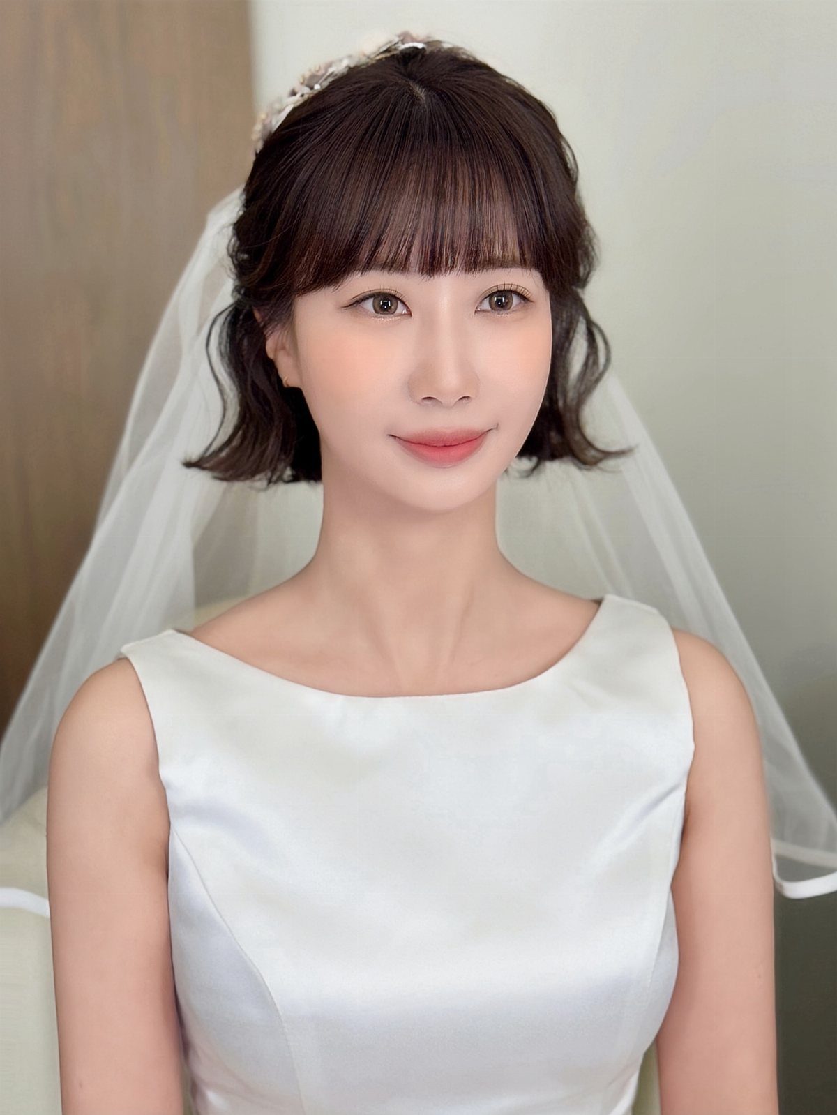 Short Wedding Hair with Veil: 5 Ideas for Brides 2 Woman with short dark hair wearing a jeweled headband veil and white dress.