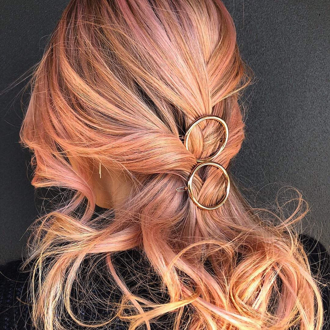 6 Side Ponytail Wedding Hairstyles for Every Bridal Look 1 Rose-gold wavy hair in a side ponytail secured with two gold metal rings.