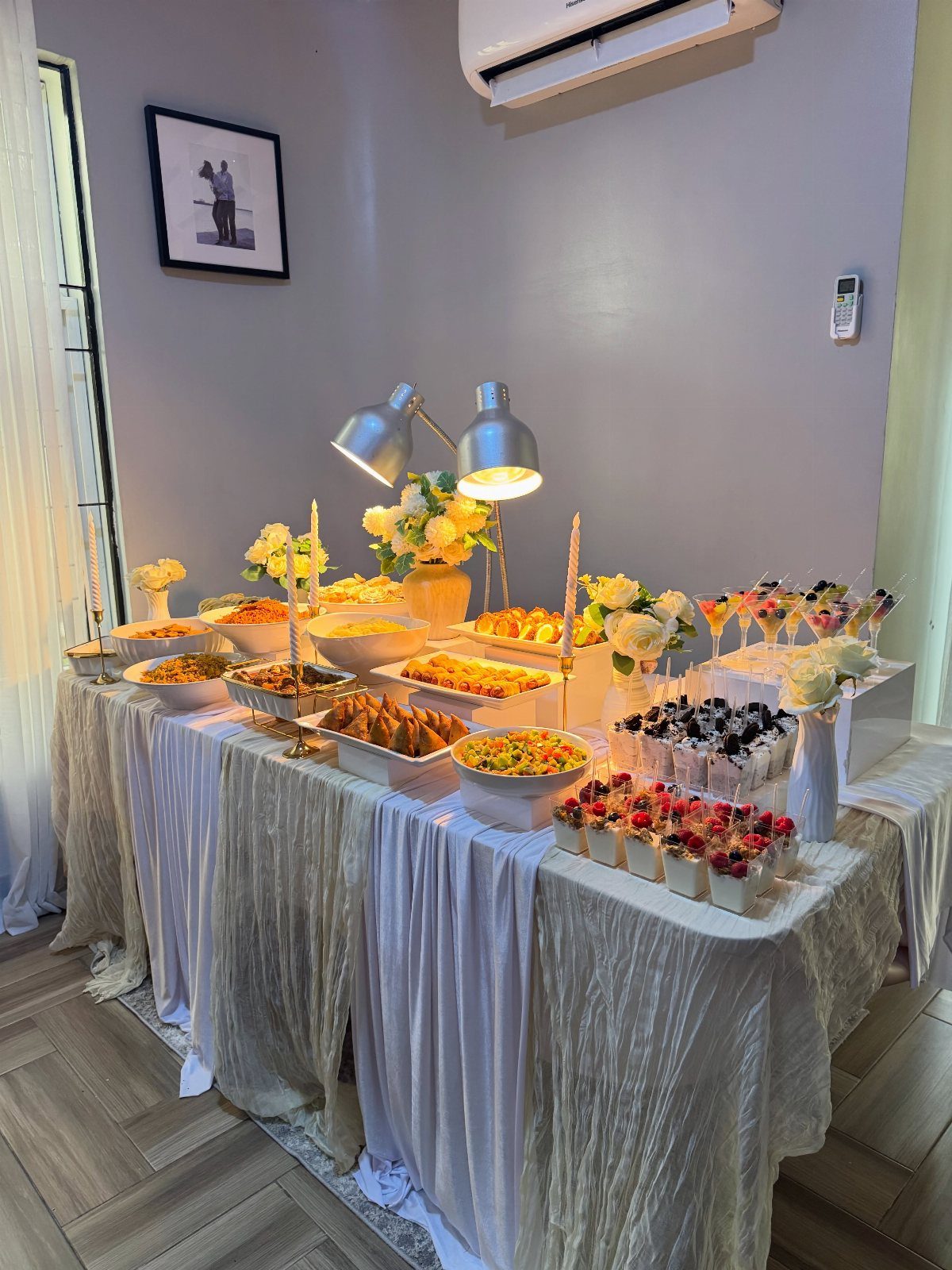 15 Small Wedding Ideas for 50 Guests, From Backyards to Parks 12 Buffet table with various appetizers and desserts decorated with white flowers and fabric.