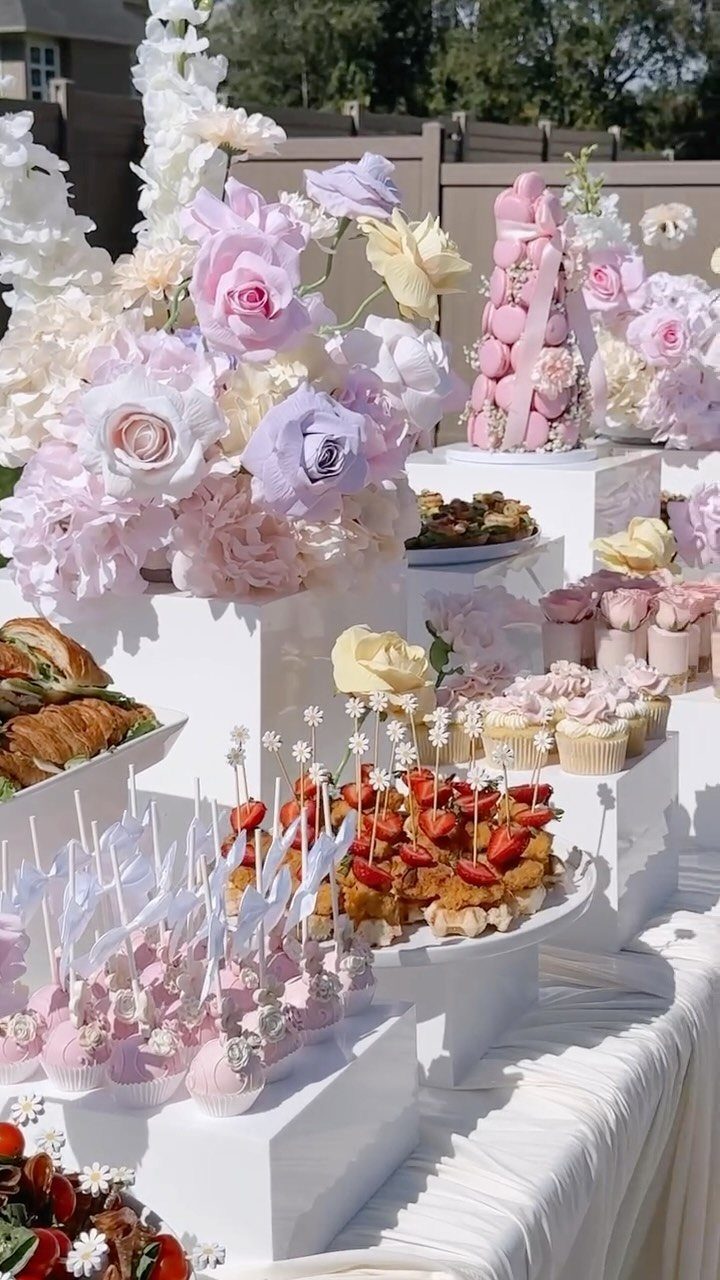 13 Small Wedding Party Ideas for an Intimate Celebration 9 Dessert and appetizer table with pink roses, macarons, and strawberry tarts for a wedding.