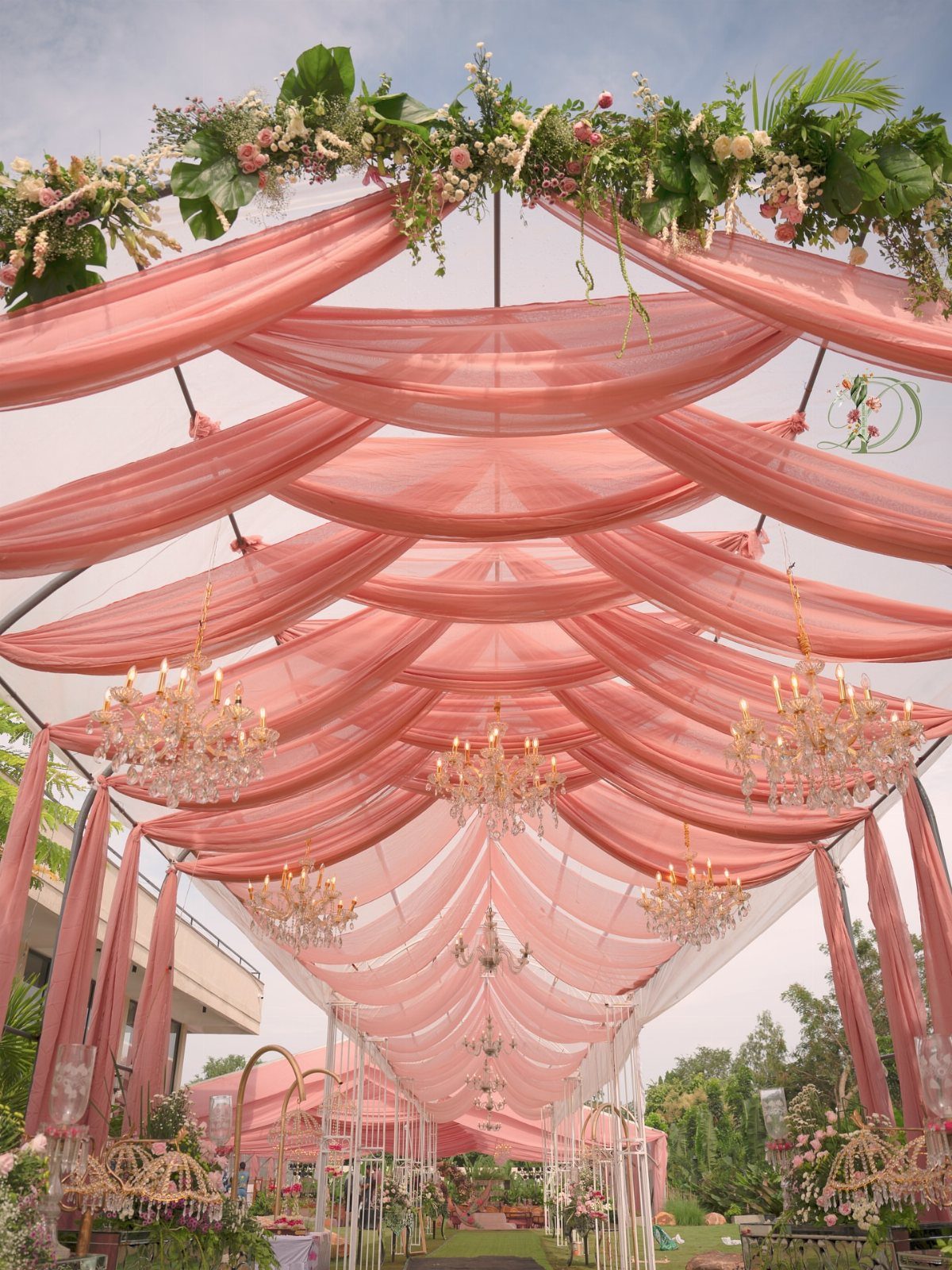 16 Tent Wedding Ideas for Lighting, Tables and Cozy Corners 9 Peach draped fabric and crystal chandeliers inside a decorated wedding tent.