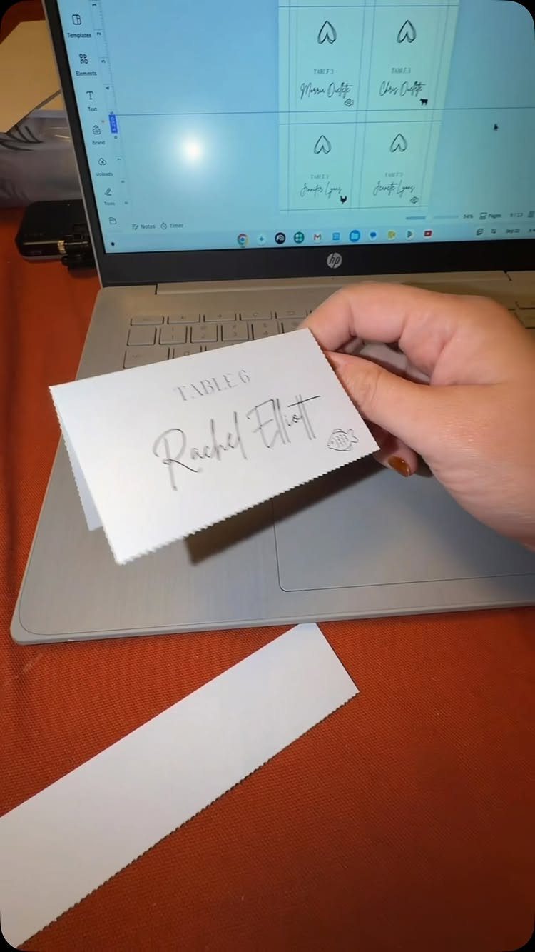 16 Tent Wedding Ideas for Lighting, Tables and Cozy Corners 13 White folded place card for Rachel Elliot at Table 6 held over laptop.