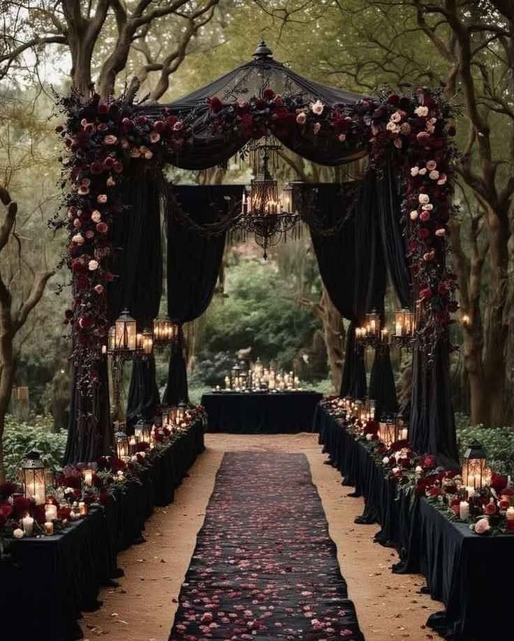 9 Uncommon Wedding Colors for Couples Who Skip the Usual 8 Black and burgundy wedding altar with floral arrangements and candles in a forest setting