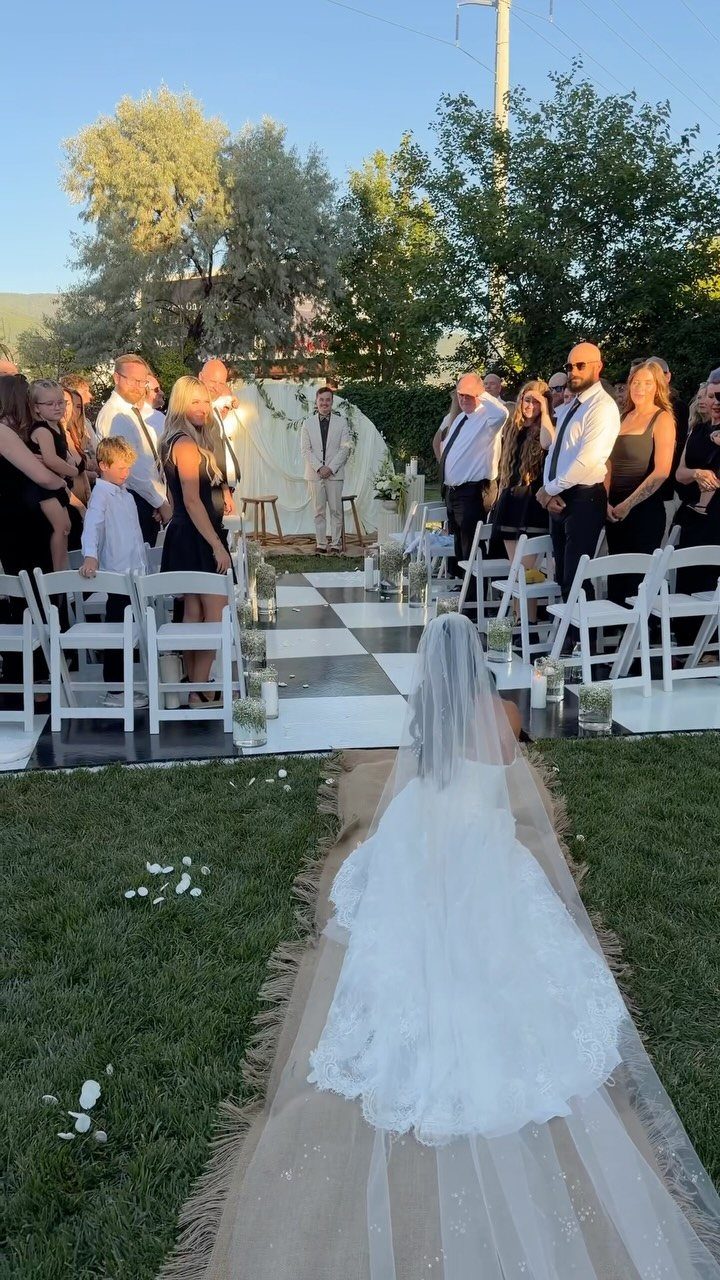 Bride walking down the aisle toward a groom standing alone at the altar.