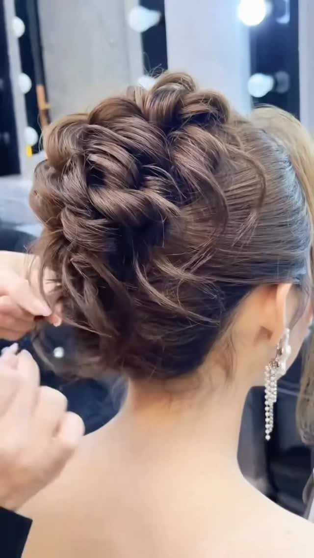 Brown hair styled in a soft romantic updo with loose, textured twists.