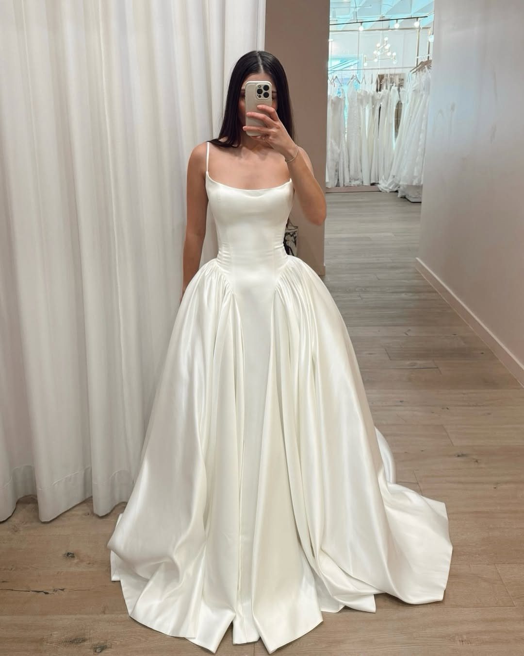 9 Ideas for a Vintage Basque Waist Wedding Dress 1 Woman wearing a white satin basque waist ball gown wedding dress in a boutique.