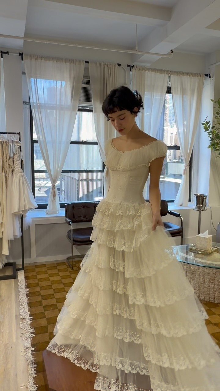 9 Ideas for a Vintage Basque Waist Wedding Dress 8 Woman wearing a white vintage basque waist wedding dress with tiered lace ruffles.