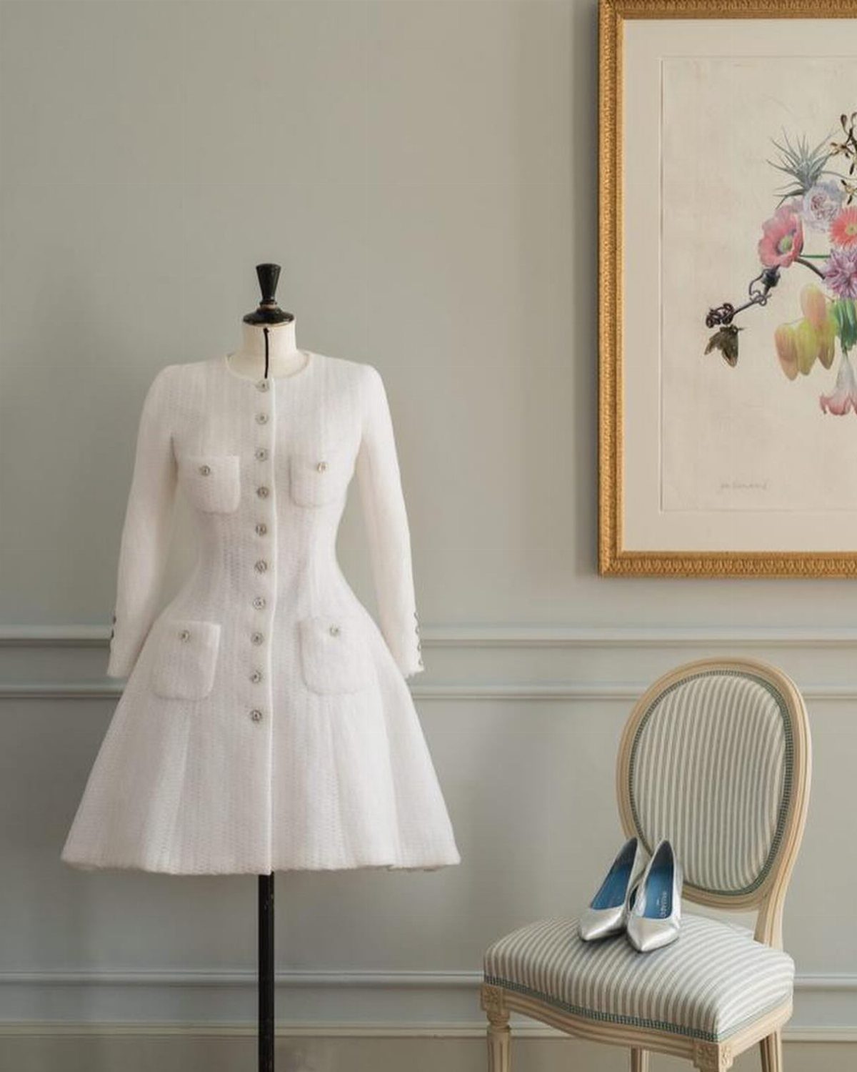 Vintage Chanel Wedding Dress Ideas: 8 Bridal Looks 7 White tweed dress on a mannequin with white heels on a striped chair.