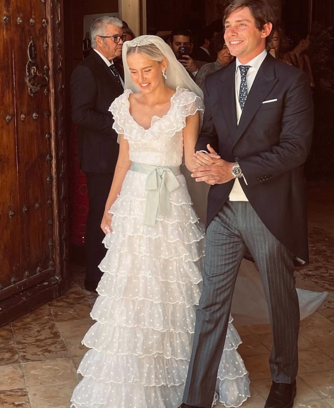 Vintage Chanel Wedding Dress Ideas: 8 Bridal Looks 5 Bride in a white ruffled wedding dress and groom in a morning suit.