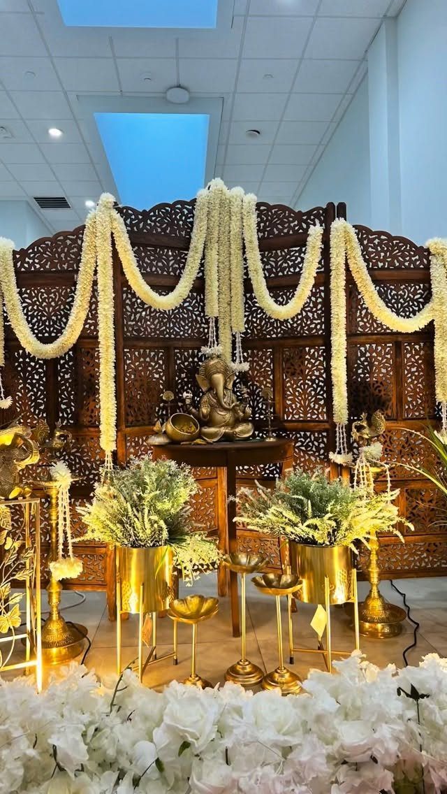 19 Wedding Backdrop Decorations for Any Ceremony Style 17 Carved wooden wedding backdrop with white flower garlands and gold decorative accents.