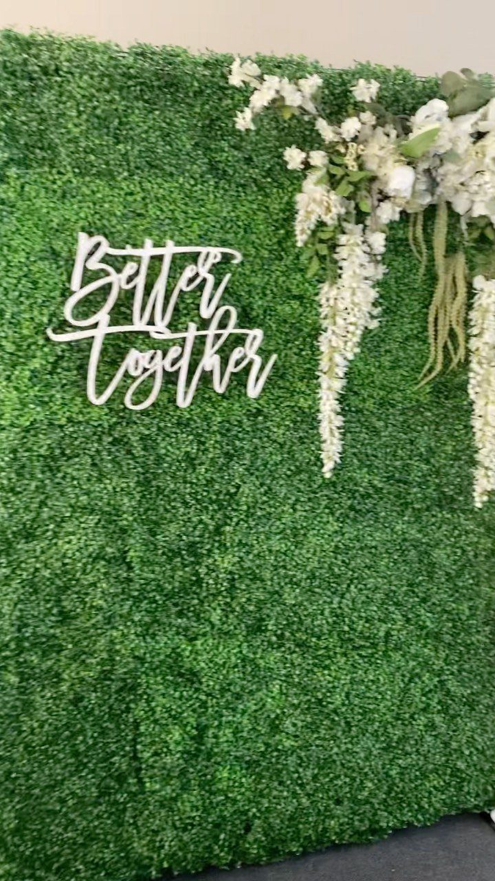 19 Wedding Backdrop Decorations for Any Ceremony Style 18 Green hedge wall backdrop with white Better Together sign and white floral arrangements.