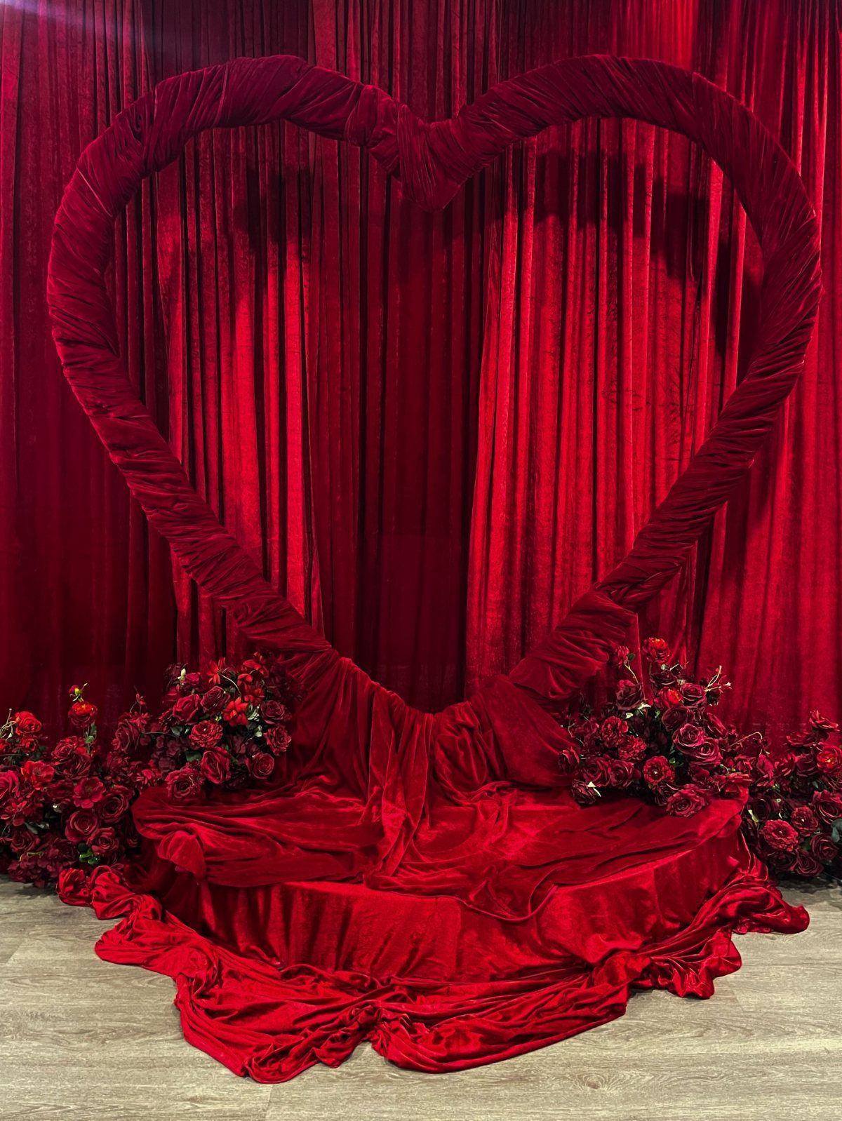 19 Wedding Backdrop Decorations for Any Ceremony Style 9 Red velvet heart frame backdrop with red roses and velvet curtains