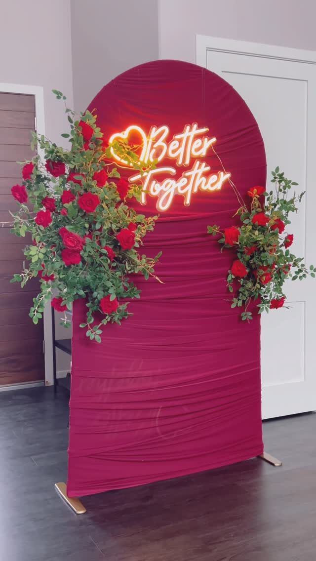 19 Wedding Decorations at Home: DIY Ideas to Try 5 Red fabric circular backdrop with neon Better Together sign and red rose floral arrangements.