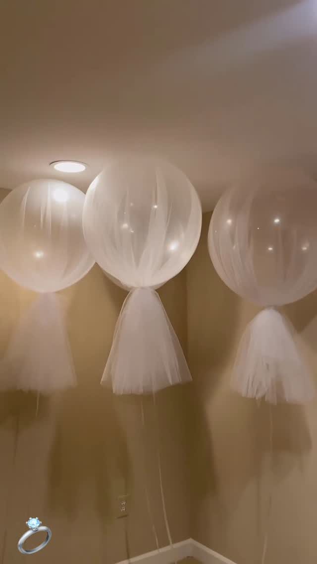 19 Wedding Decorations at Home: DIY Ideas to Try 14 Three white balloons with tulle skirts floating against a neutral indoor wall