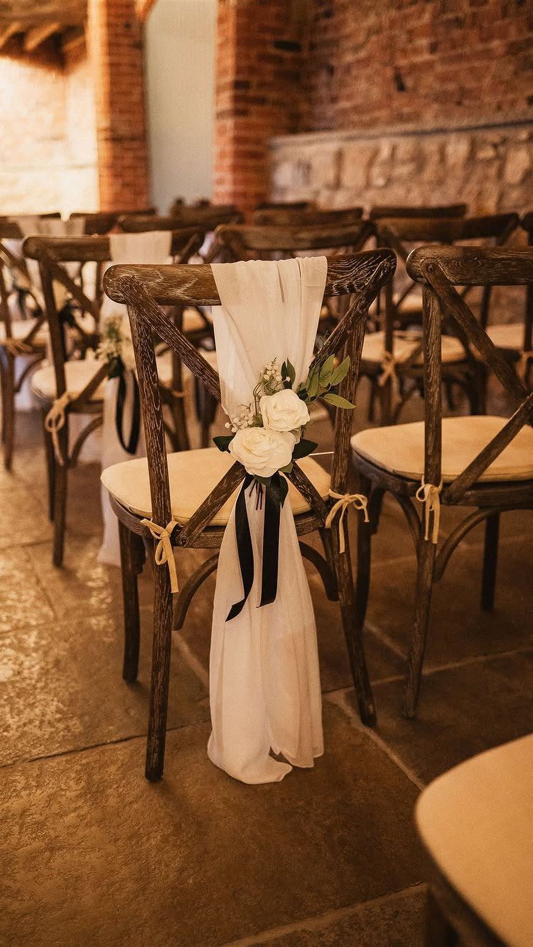 19 Wedding Decorations at Home: DIY Ideas to Try 6 Wooden cross-back wedding chair decorated with white fabric, black ribbon, and white roses.