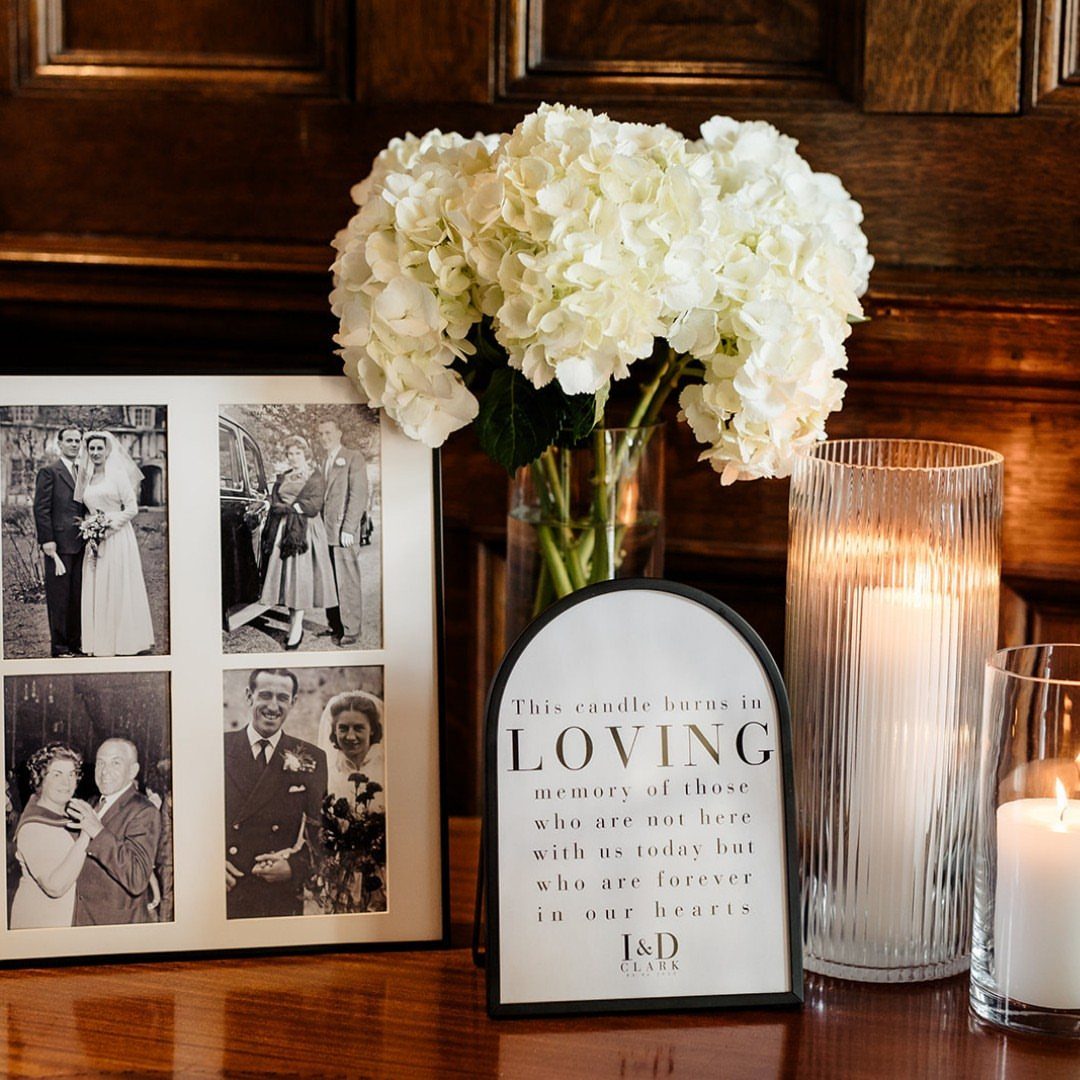 19 Wedding Decorations at Home: DIY Ideas to Try 15 Memory table with framed wedding photos, white hydrangeas, lit candles, and a memorial sign.