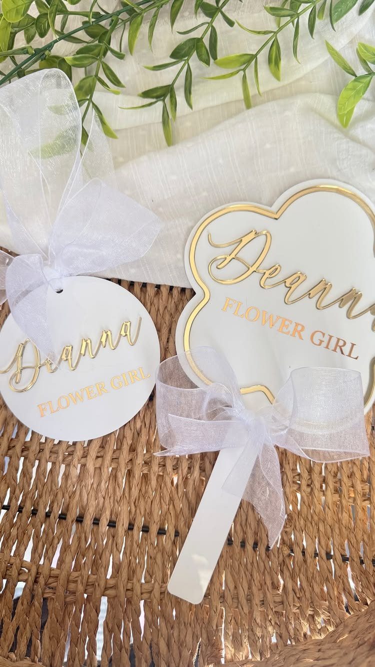 19 Wedding Decorations at Home: DIY Ideas to Try 1 White and gold flower girl signs with sheer bows on a wicker surface.