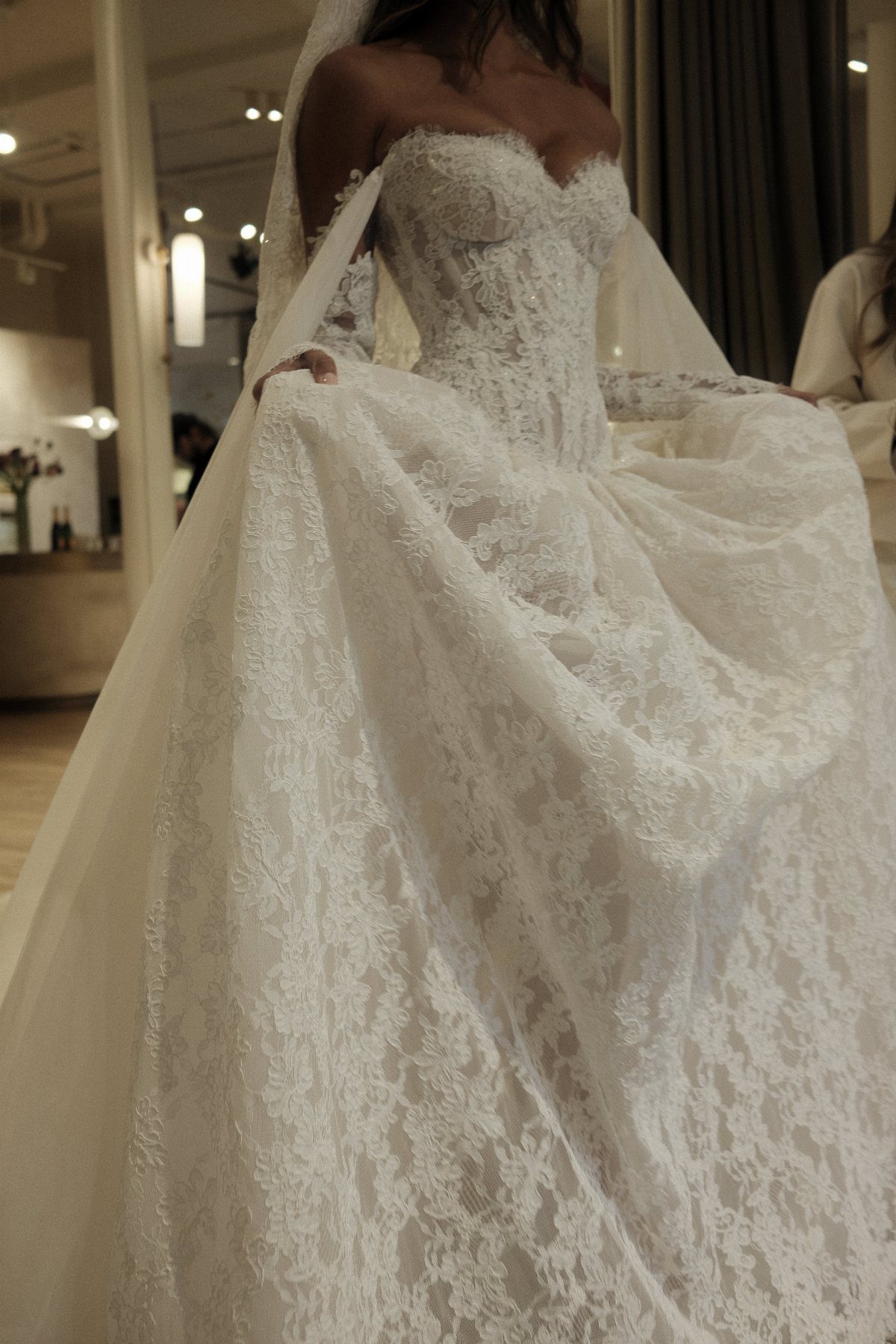 White lace wedding dress with a full skirt and sheer bridal veil.