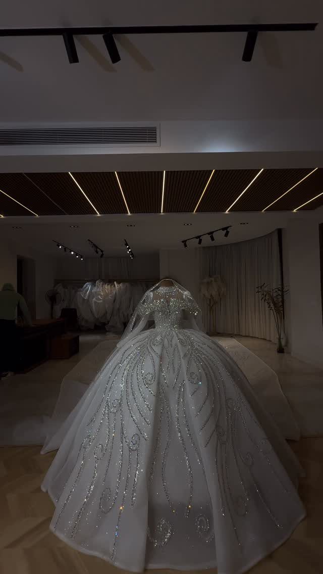 White ballgown wedding dress with shimmering silver beadwork and intricate embroidery on a mannequin.