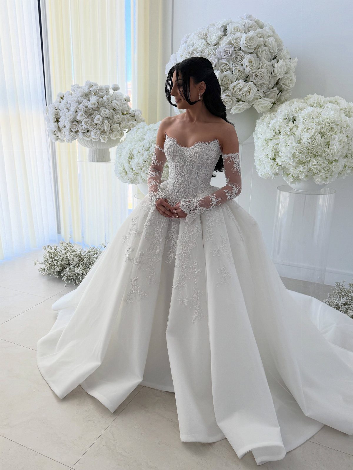 Wedding Dress Options: 8 Silhouettes From A-Line to Vintage 2 Woman in a white lace ball gown wedding dress surrounded by white roses