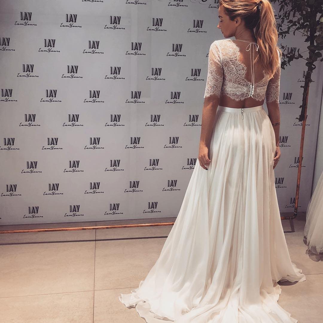 Woman wearing a white lace crop top and long flowing white wedding skirt.