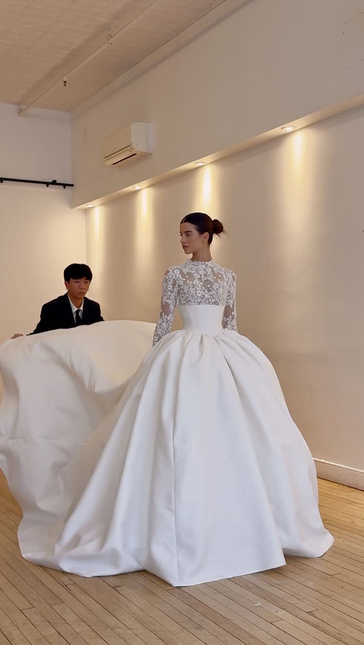 Wedding Dresses Elegant and Classy: 14 Gown Styles 4 Woman in a white wedding dress with lace sleeves and a full satin skirt.