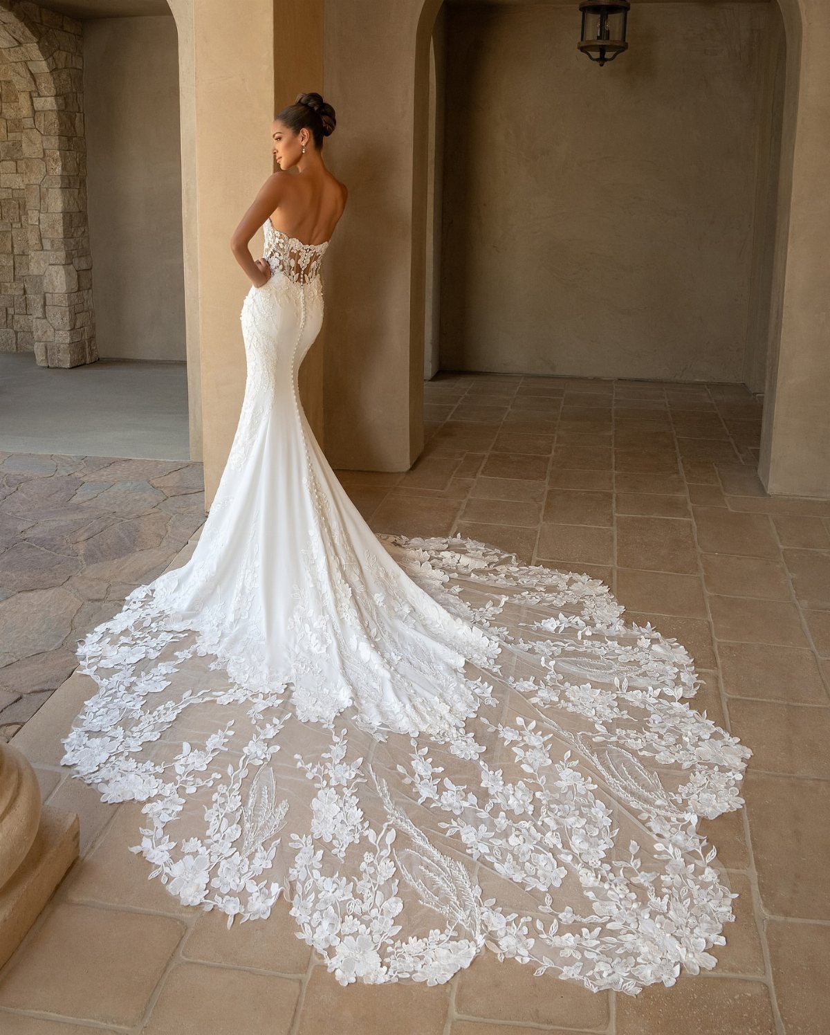 Wedding Dresses Elegant and Classy: 14 Gown Styles 12 Woman in a strapless mermaid wedding dress with a long lace train in a courtyard
