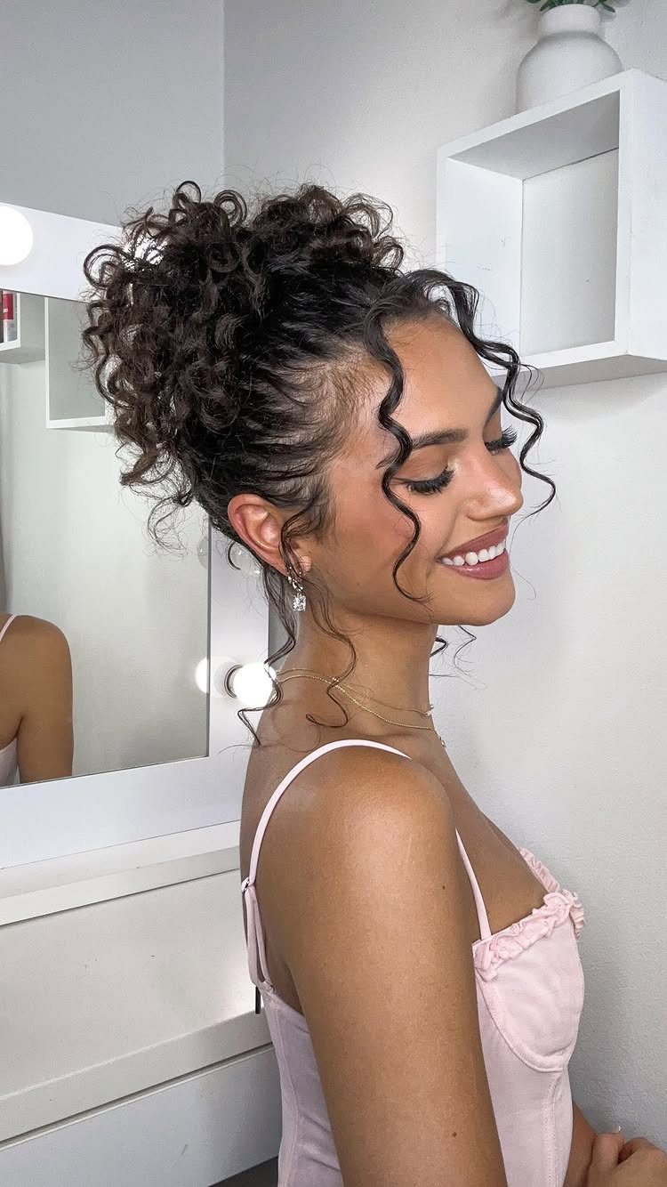 Woman with curly brown hair styled in an elegant high curly chignon updo.