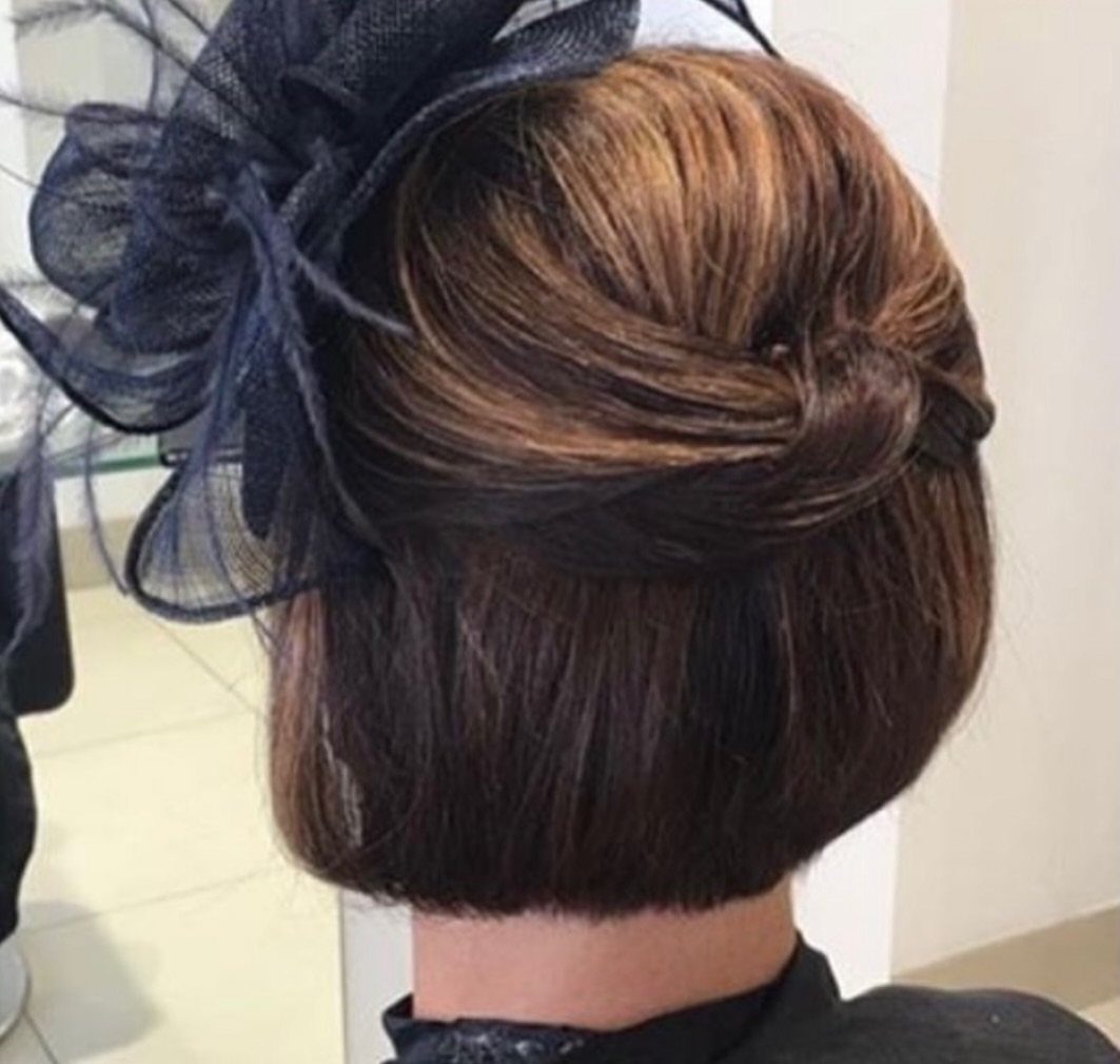 Faux bob hairstyle with brown hair and a navy blue mesh fascinator hat.