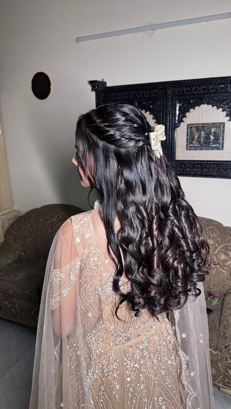 Woman with dark curly hair in a half-up half-down style wearing a beige gown