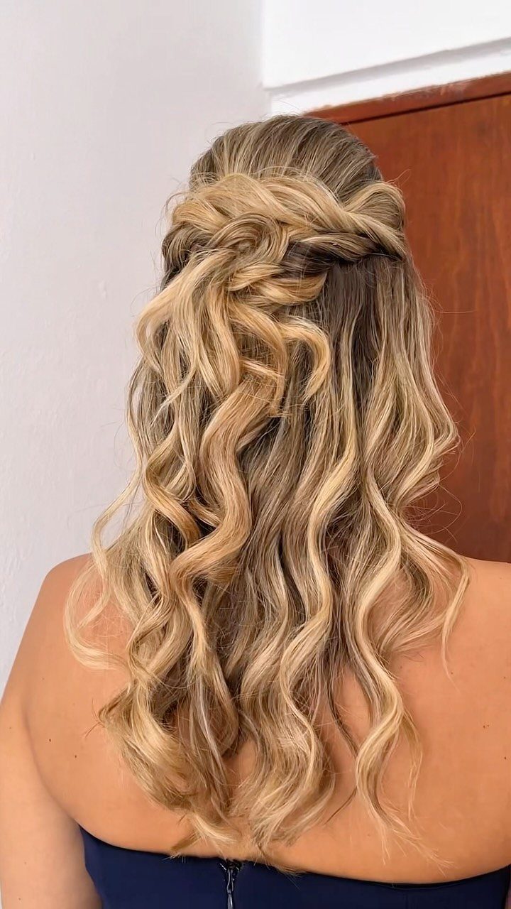 Blonde medium hair styled in a twisted half-updo with long, voluminous curls.