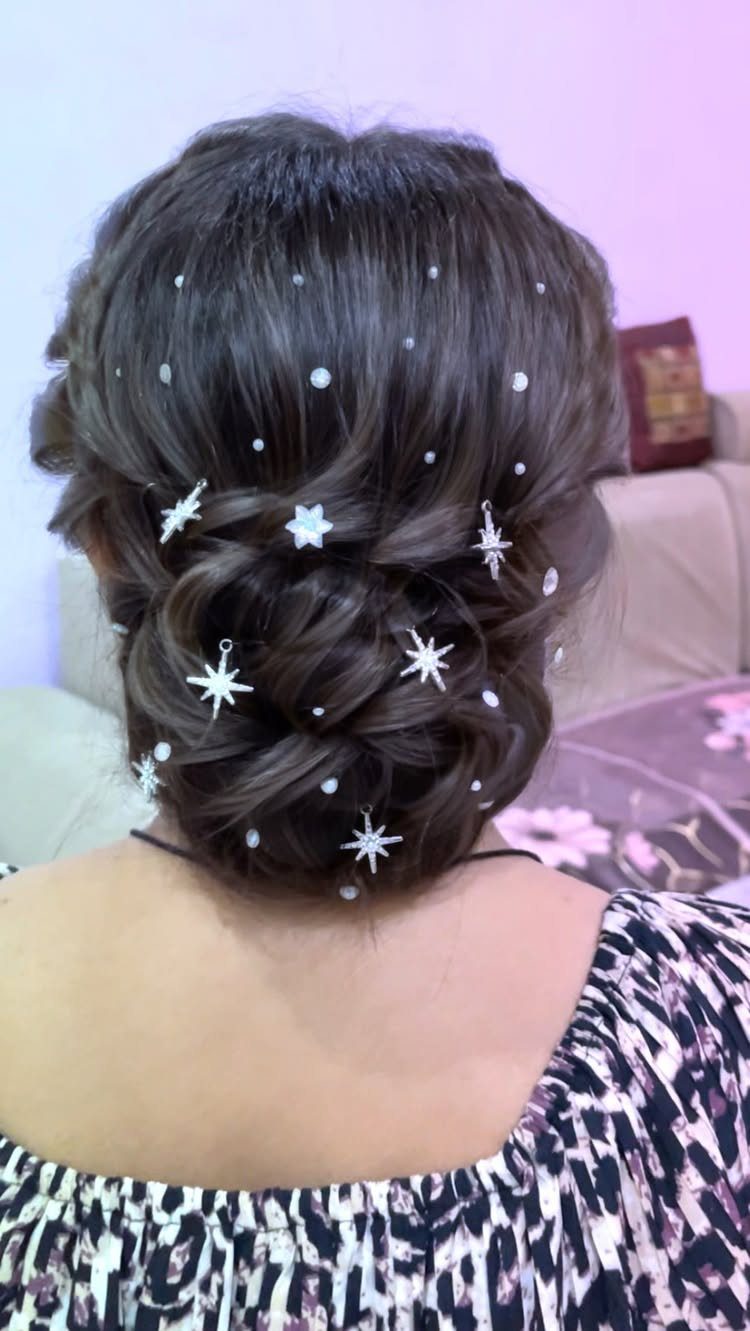 Brown hair styled in a twisted low knot bun with white star accessories.