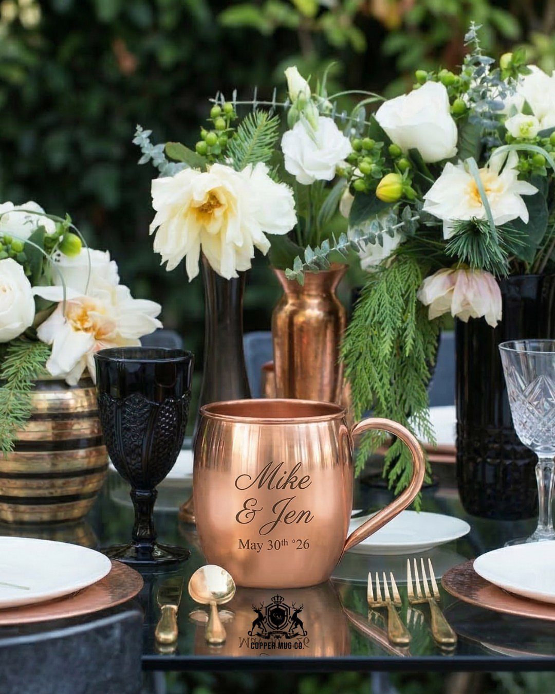 30 Wedding Guest Keepsakes Your Guests Will Actually Use 12 Engraved copper mug on a wedding table with white flowers and gold cutlery