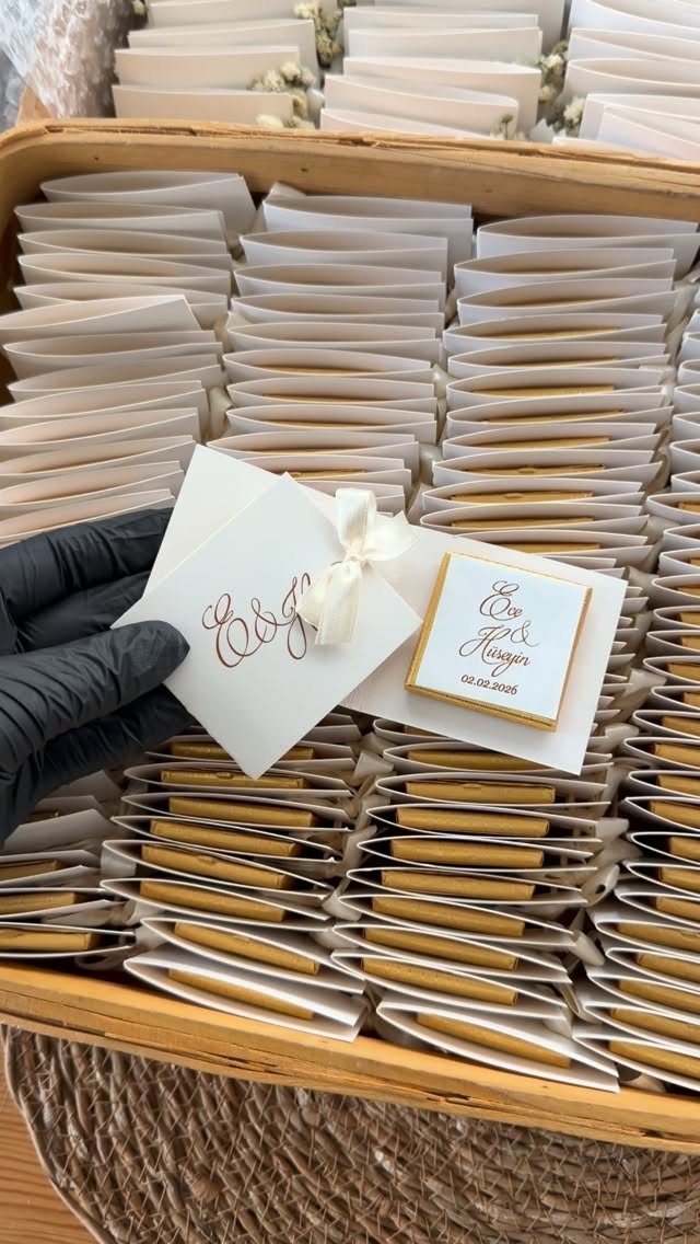 30 Wedding Guest Keepsakes Your Guests Will Actually Use 1 Square frosted cookies with gold text and white envelopes in a wooden tray