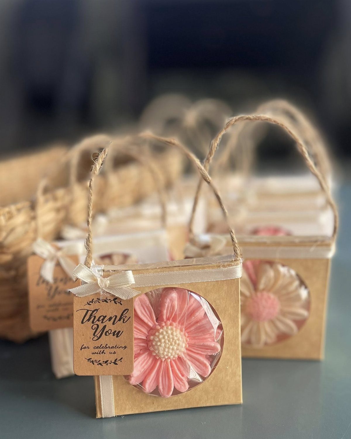 30 Wedding Guest Keepsakes Your Guests Will Actually Use 10 Pink flower-shaped soap bars in small brown cardboard gift boxes with thank you tags.