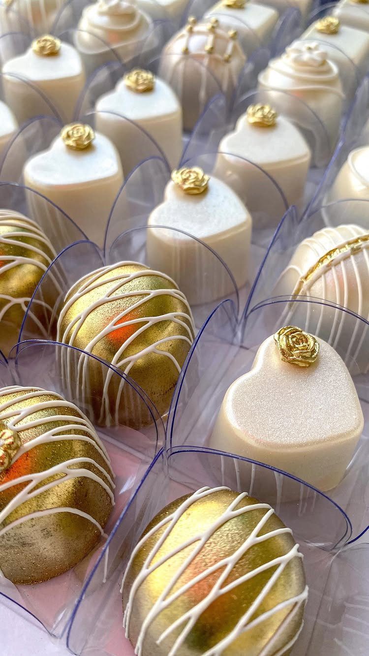 30 Wedding Guest Keepsakes Your Guests Will Actually Use 17 Heart-shaped white chocolates with gold roses and gold-dusted chocolate spheres in clear liners.