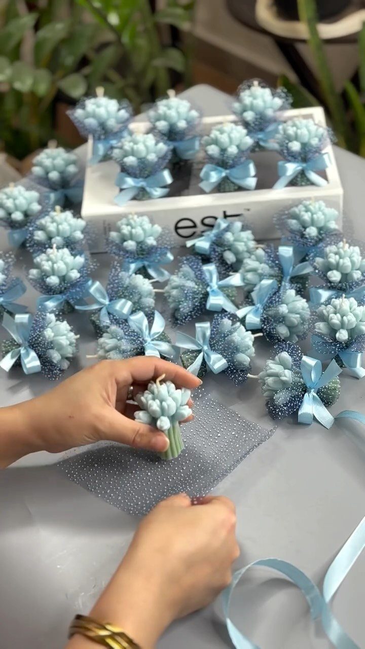 30 Wedding Guest Keepsakes Your Guests Will Actually Use 15 Small light blue floral bouquets wrapped in tulle and tied with ribbons.