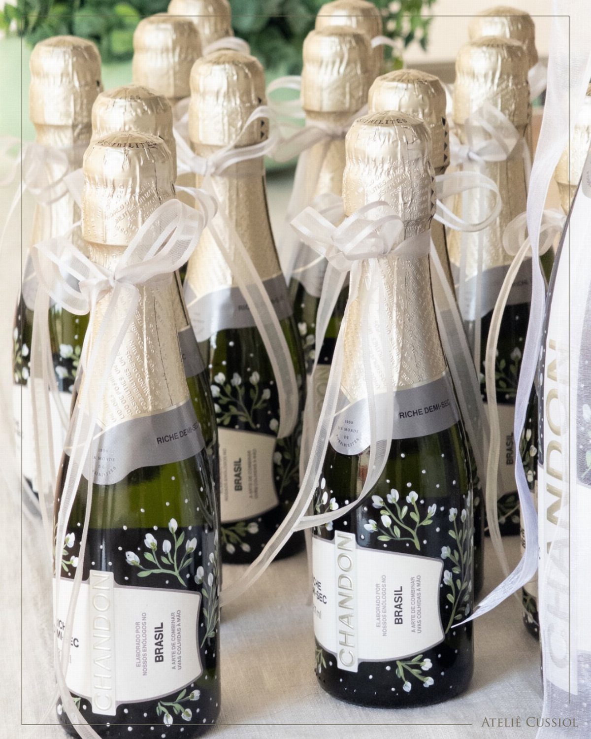 30 Wedding Guest Keepsakes Your Guests Will Actually Use 4 Mini champagne bottles with gold foil and white ribbons tied in bows.