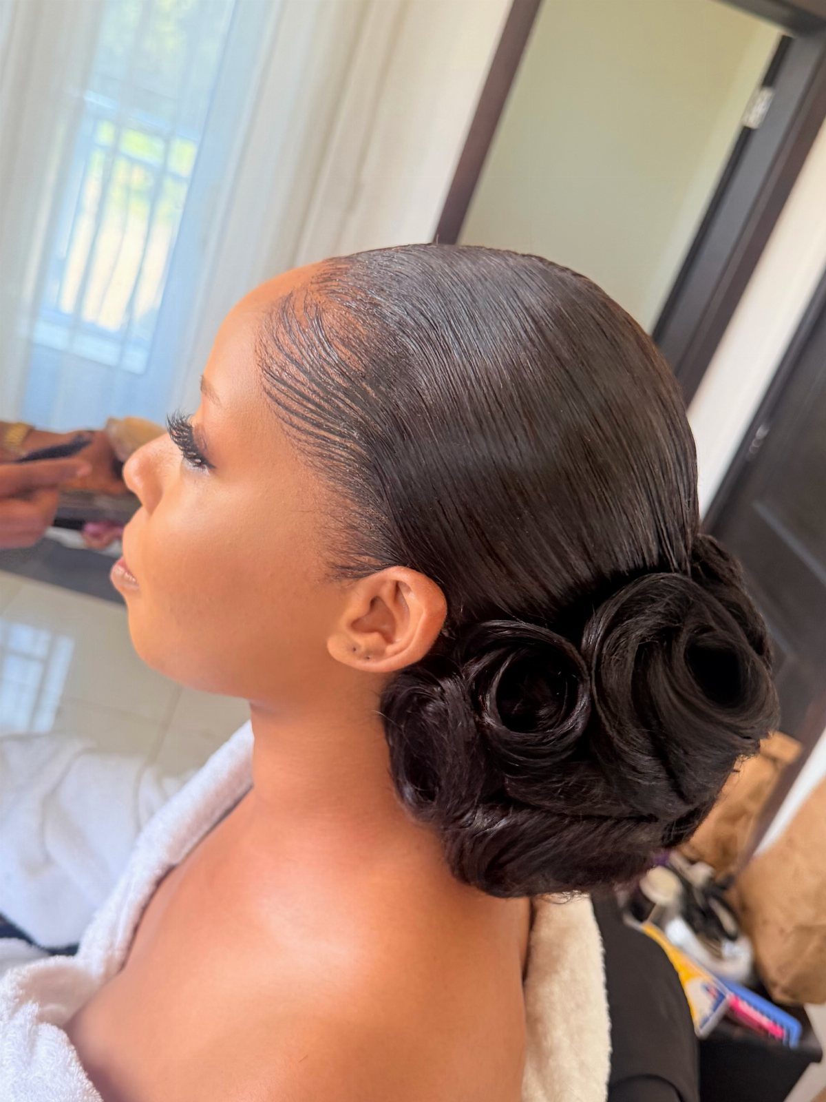 Wedding Hair Styles for Straight Hair: 9 Ideas 9 Woman with sleek straight black hair styled into a low rose-shaped bun.