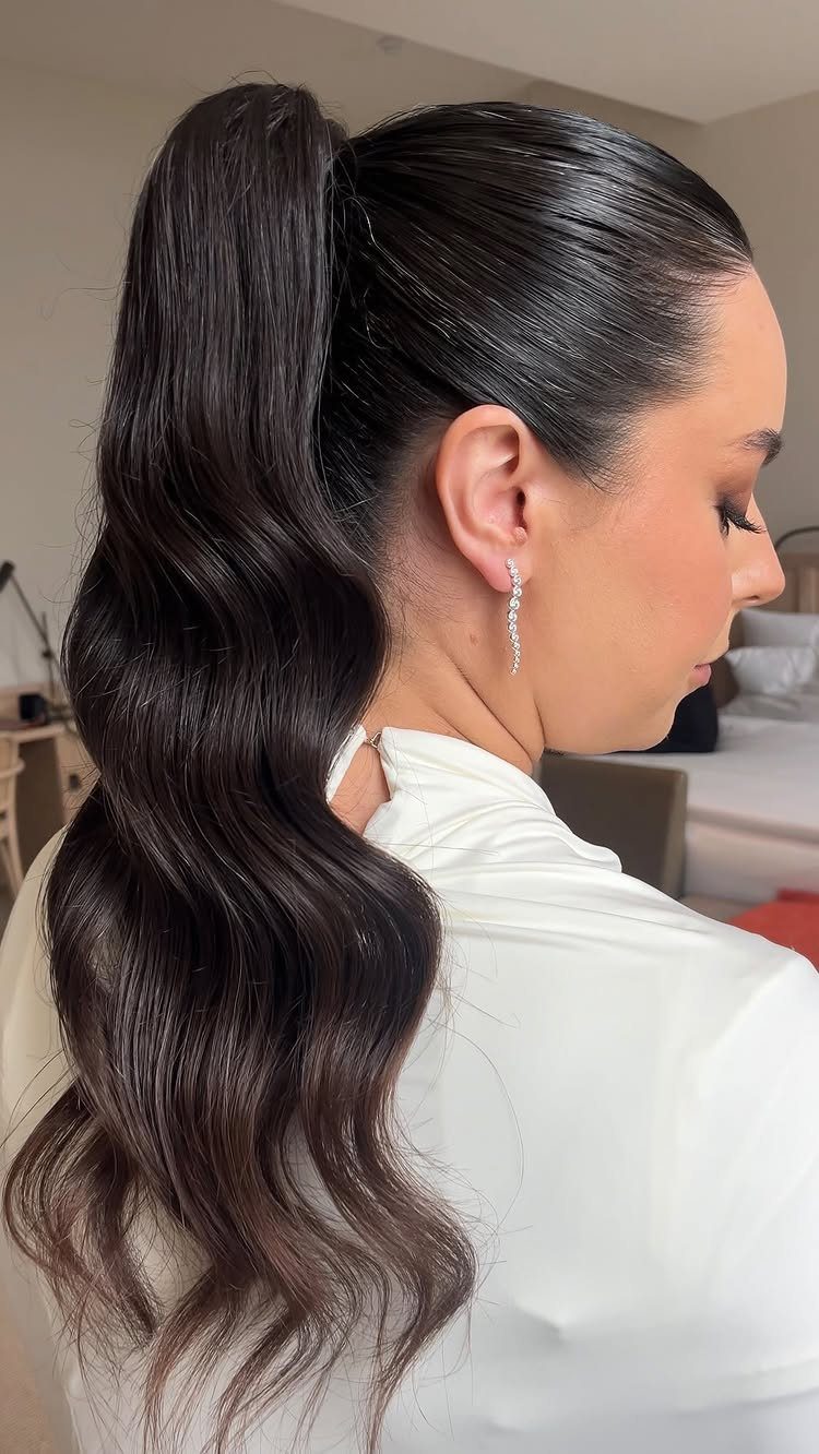 Wedding Hair Styles for Straight Hair: 9 Ideas 3 Woman with a high polished ponytail and sleek dark hair in a white dress.