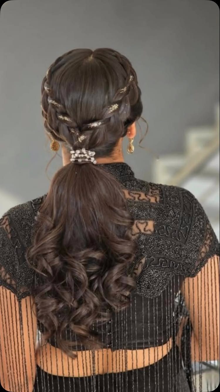 Braided ponytail with voluminous curls and a pearl hair tie on dark brown hair.