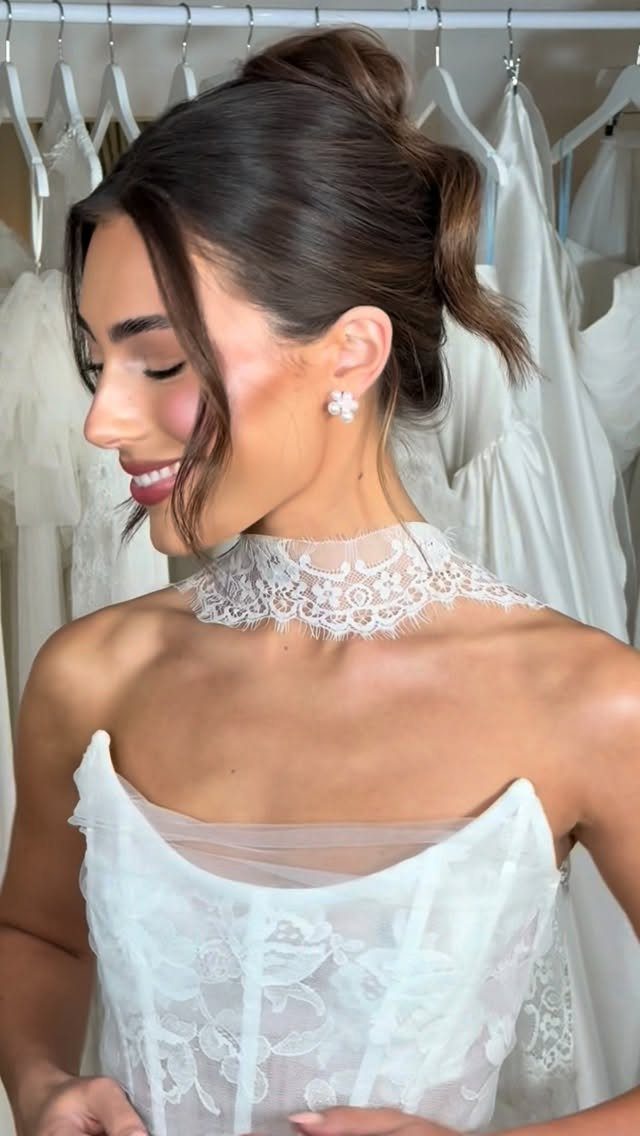 Woman with a relaxed, layered bridal updo wearing a white lace wedding dress.