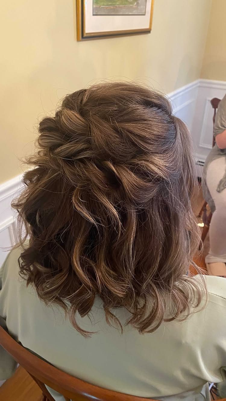 Brown hair styled in a textured half-up half-down look with loose curls.