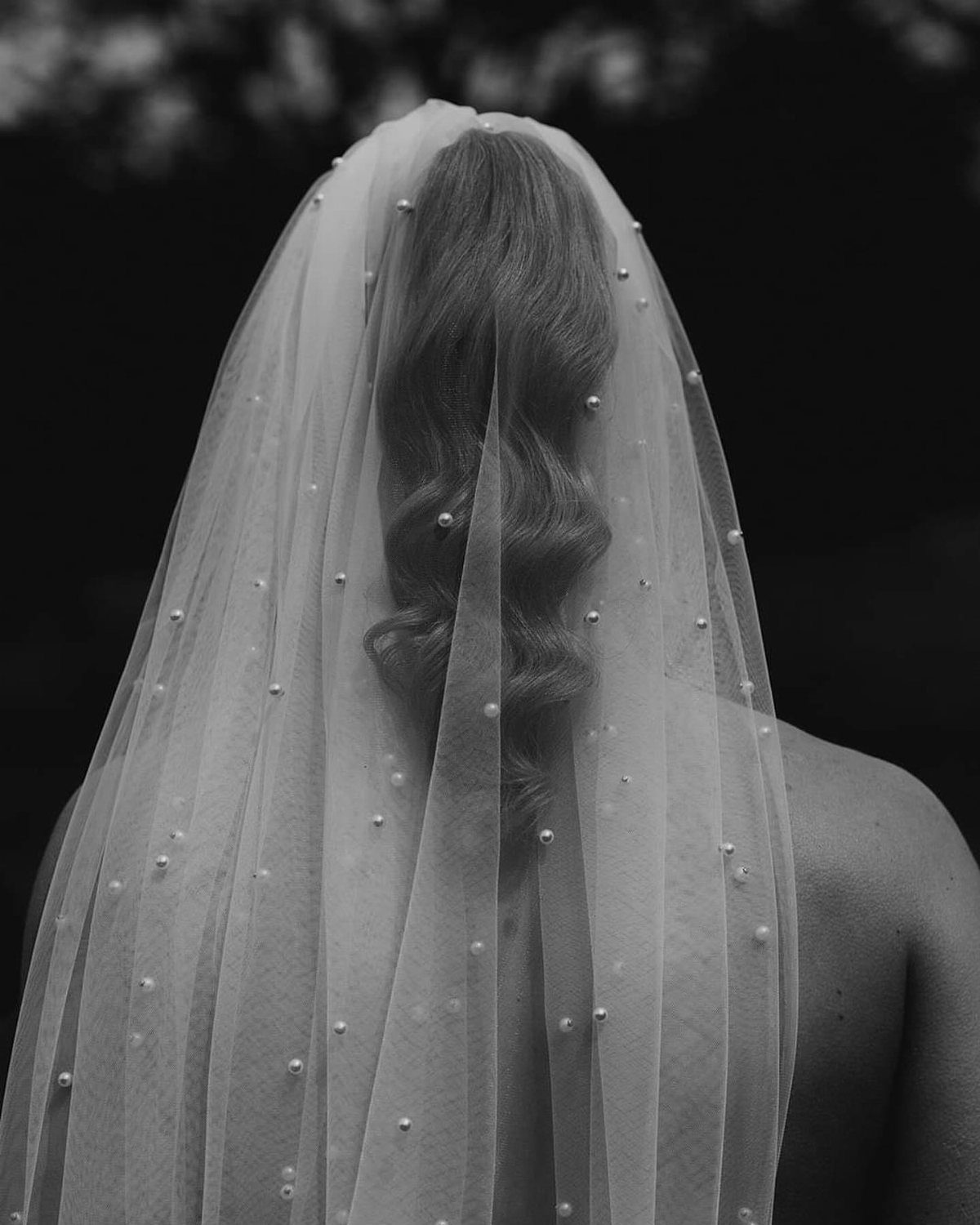 Woman with Hollywood waves hair wearing a sheer veil with pearl embellishments.