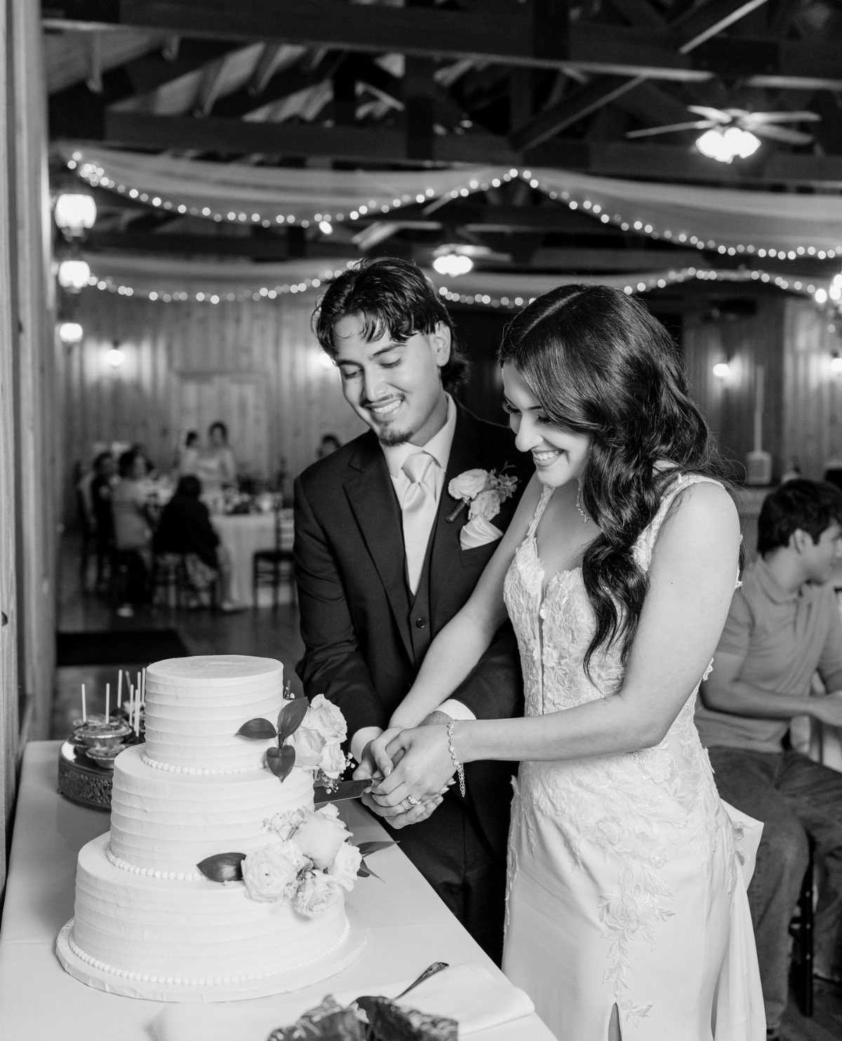 17 Wedding Ideas Pictures to Show Your Photographer 12 Bride and groom smiling while cutting a three-tiered white wedding cake together.